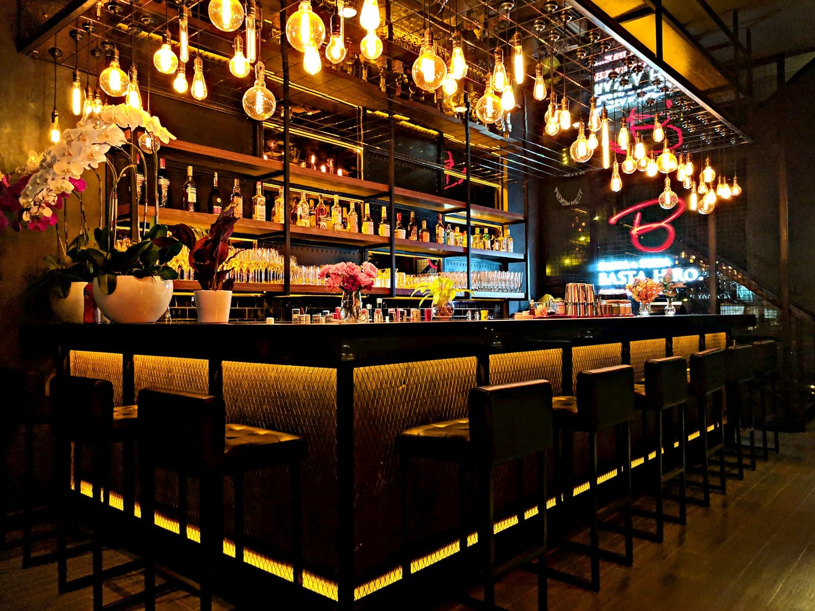 Backlit cocktail bar with hanging Edison bulbs
